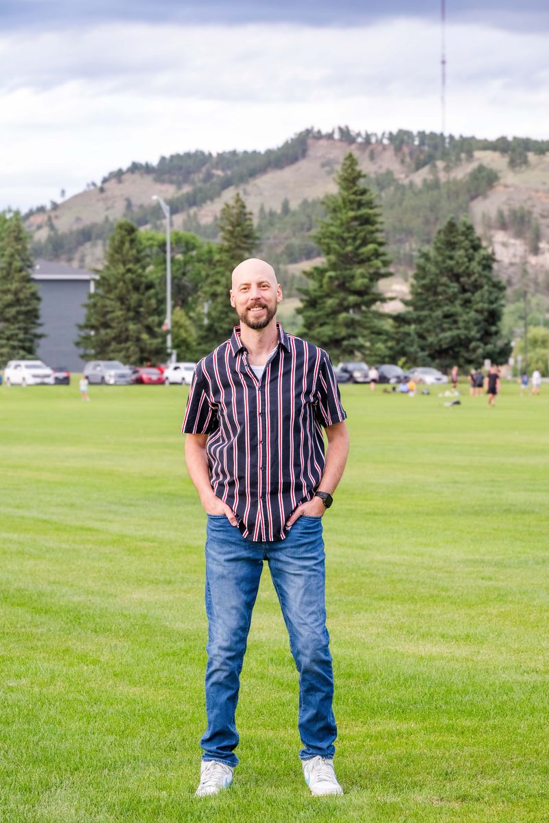 Michael Calabrese in a Rapid City park with the Black Hills behind him