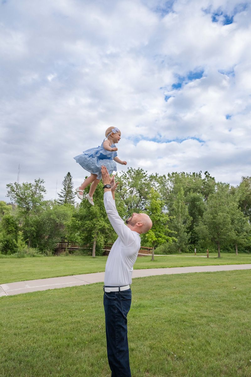 Michael Calabrese lifting his daughter toward the sky