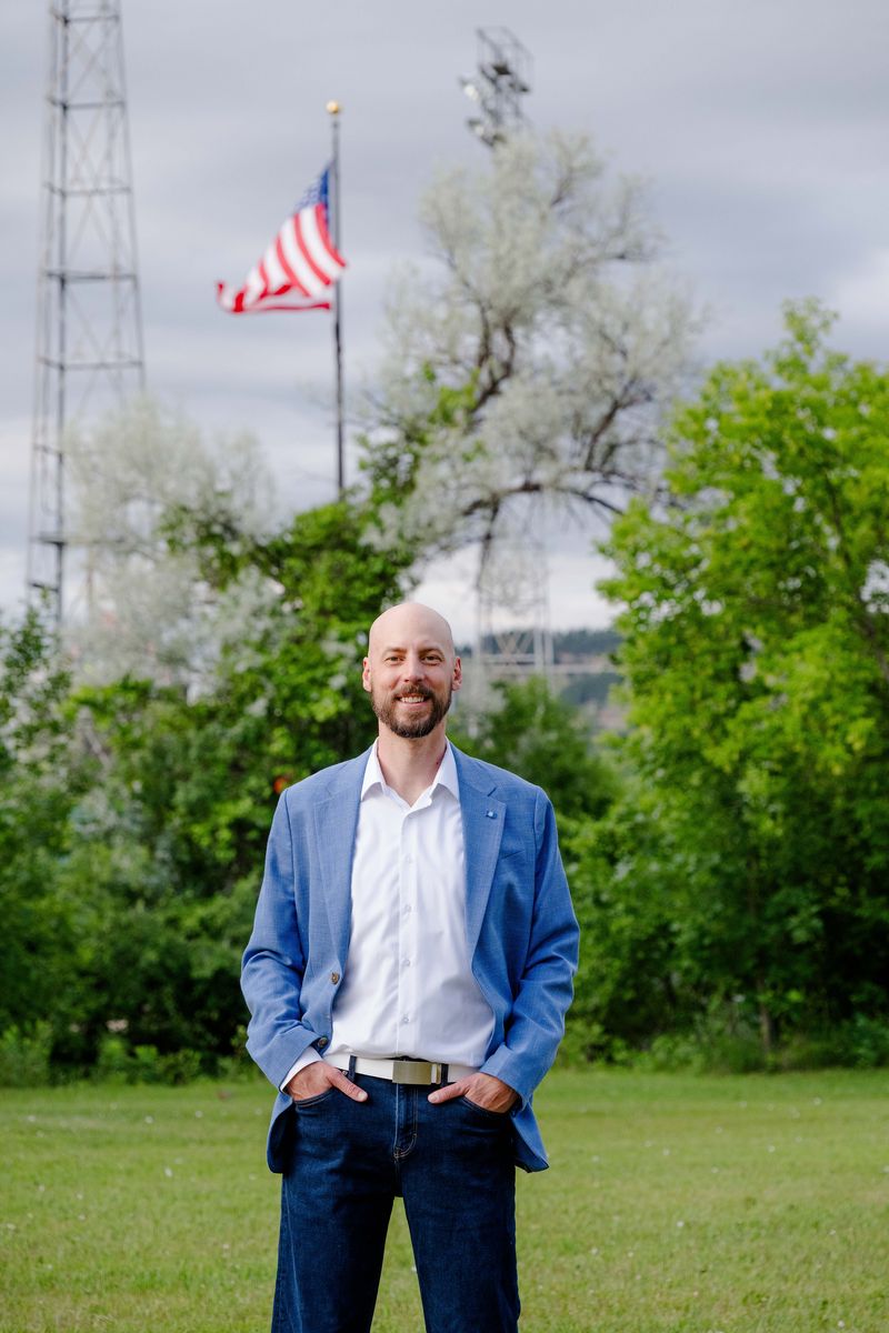 Michael Calabrese in a blue blazer with an American flag behind him